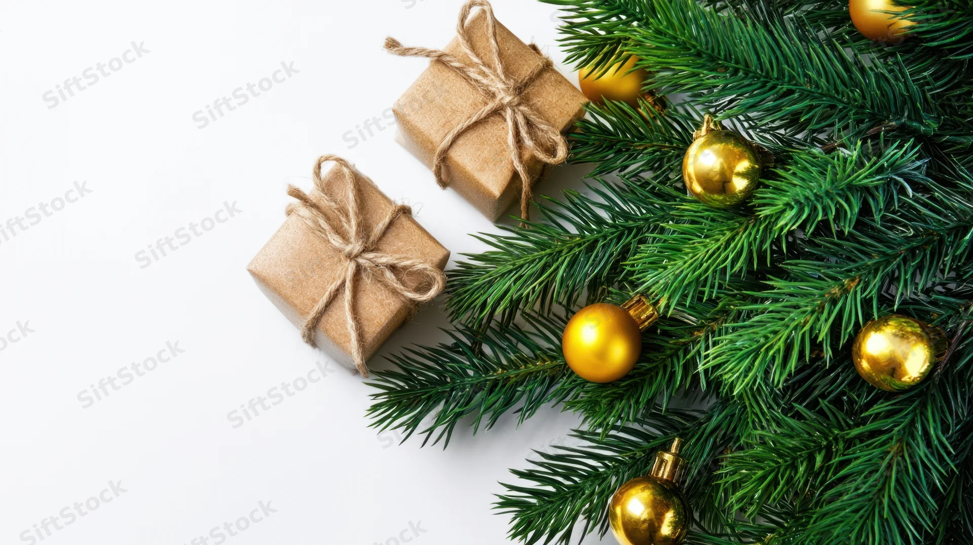 Christmas tree branch with gold ornaments and two wrapped gifts on white background