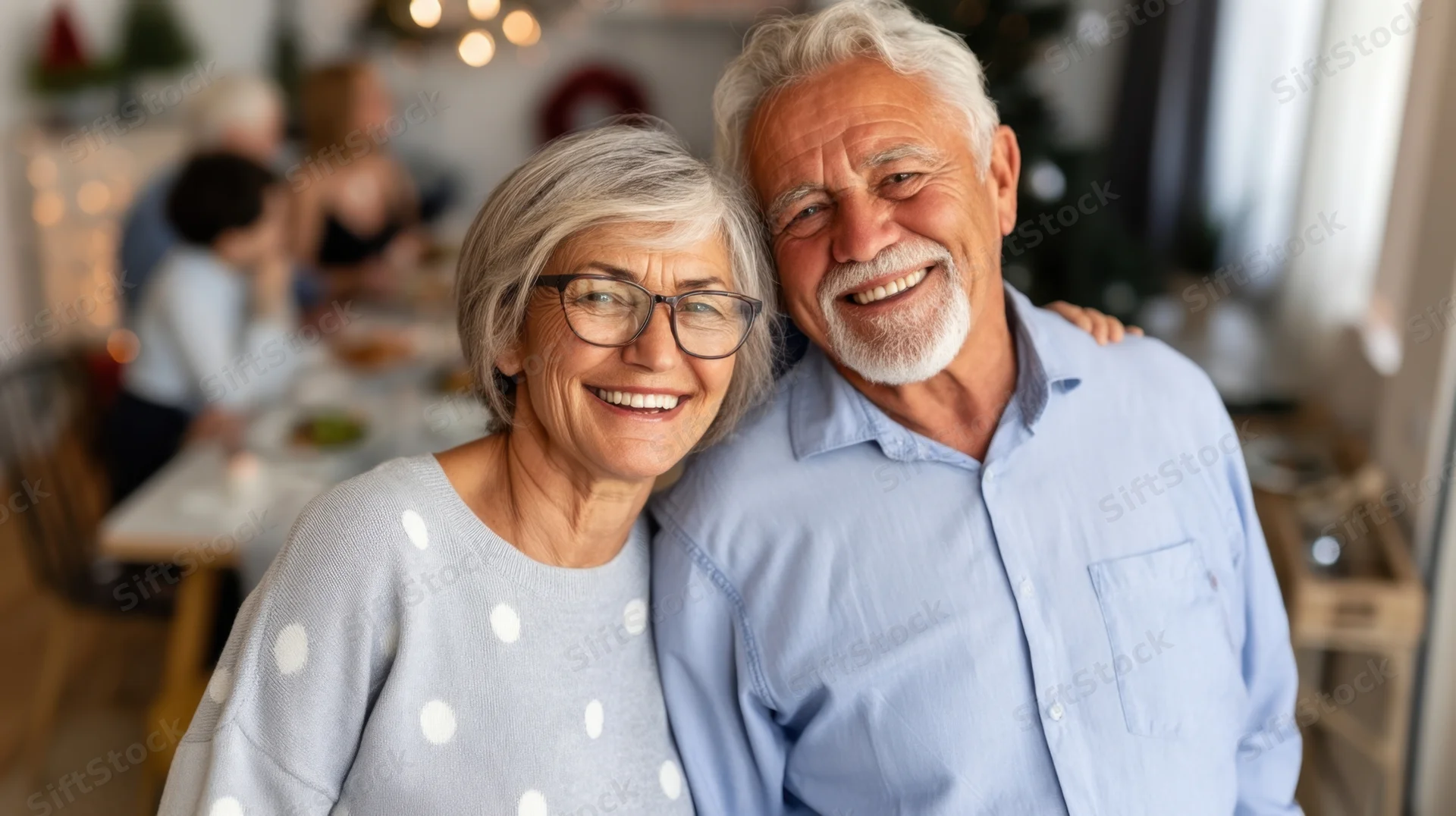 Happy senior couple smiling together at home during family holiday gathering