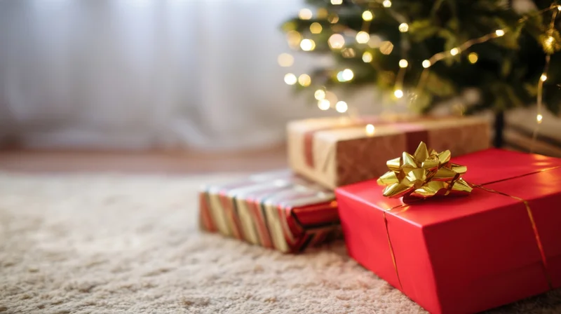 Wrapped christmas gifts on carpet near decorated tree with lights