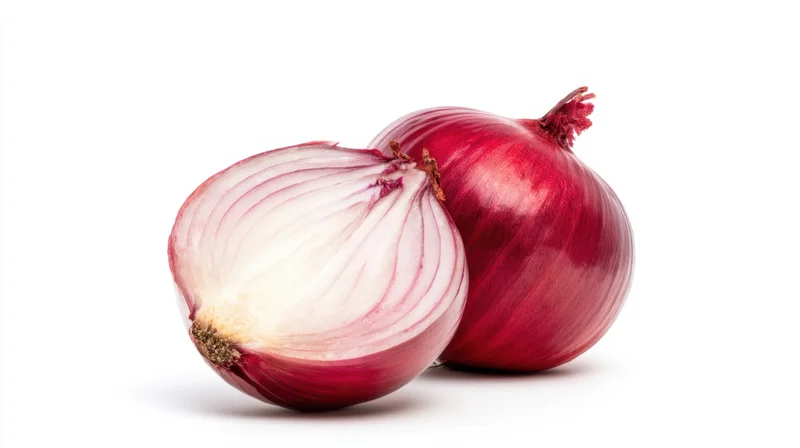 Two red onions, one sliced and one whole, on a white background