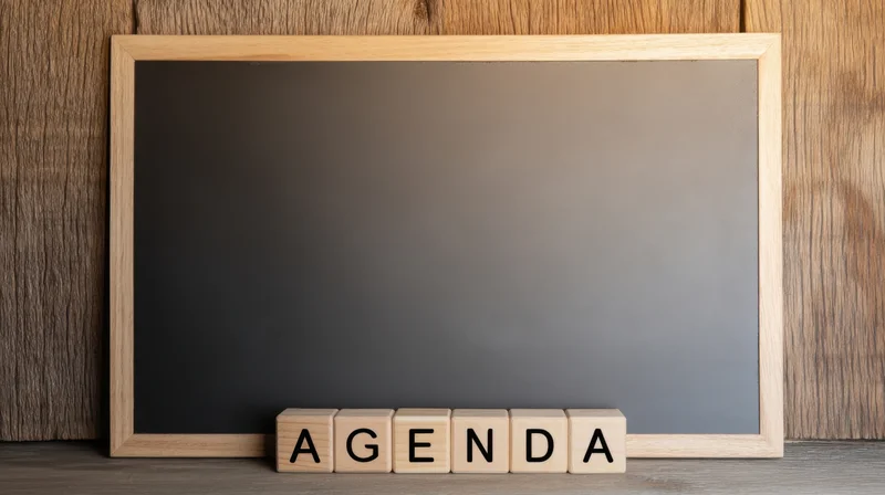 Wooden-framed chalkboard with wooden blocks spelling agenda on a desk surface
