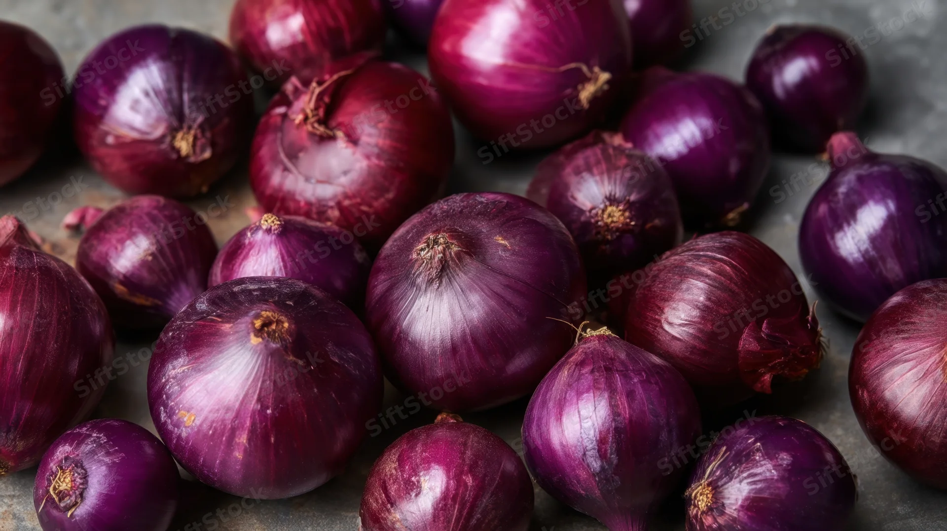 Close-up of red onions piled on a stone surface