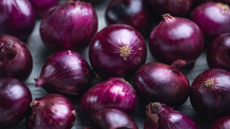 Close-up of red onions arranged on a dark surface