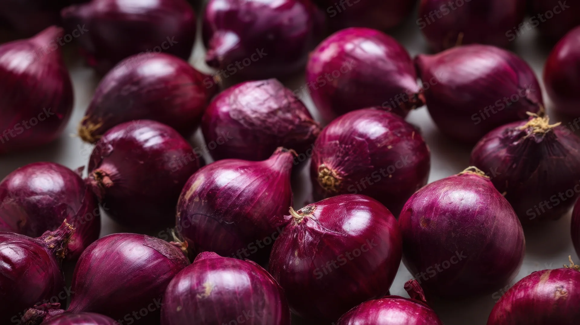 Close-up of red onions piled together on a flat surface