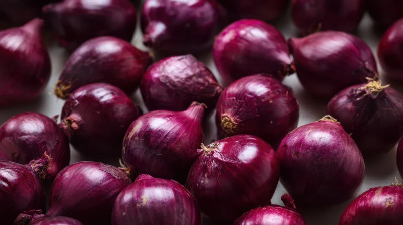 Close-up of red onions piled together on a flat surface
