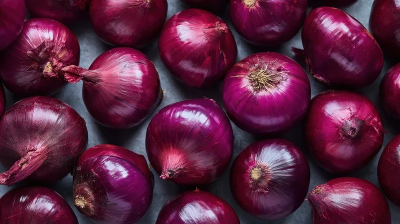 Close-up of red onions arranged on a dark surface