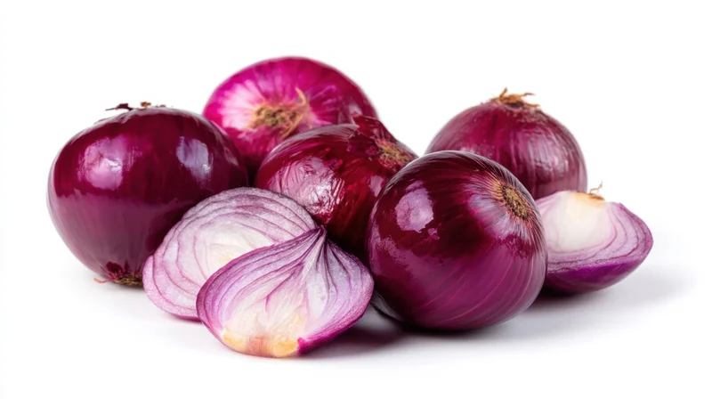 Whole and sliced red onions arranged on a white surface