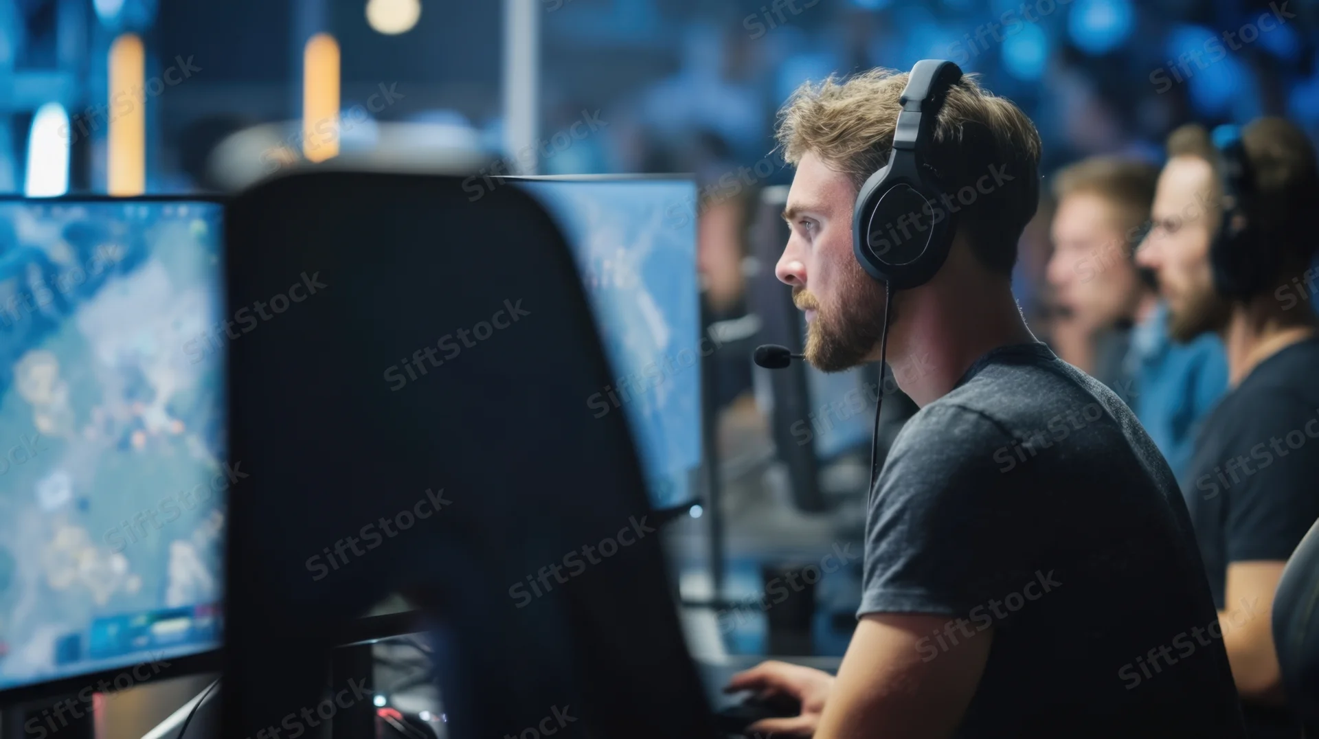 Gamer wearing headset focused on computer screen during esports competition