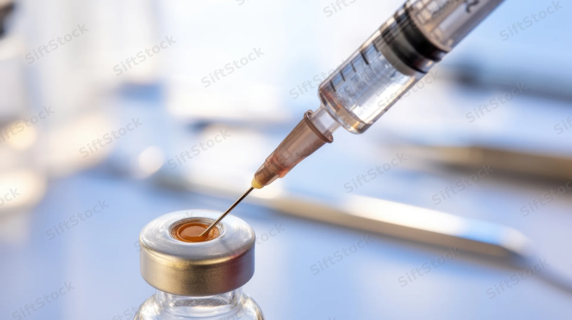Syringe drawing liquid from a vaccine vial in a medical setting