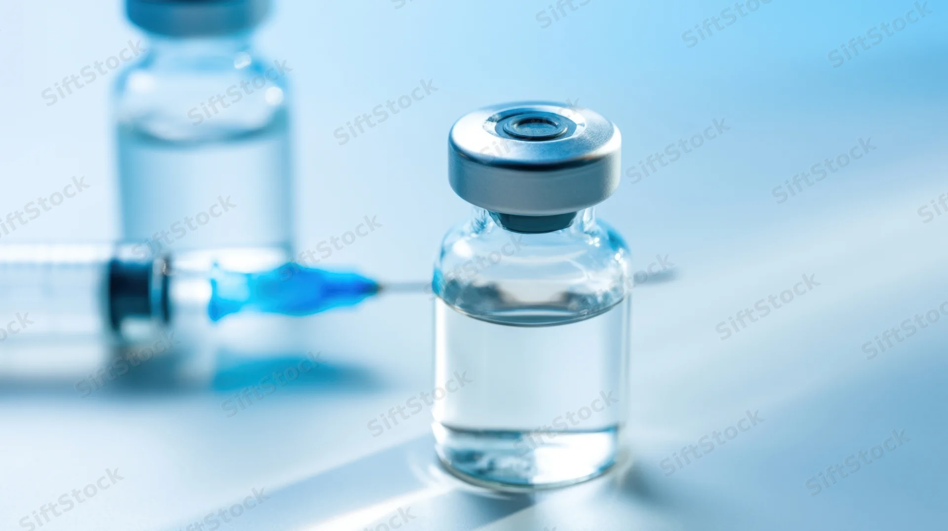 Vaccine vial with syringe on a clinical surface