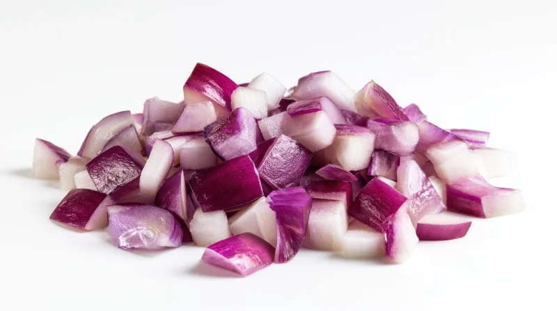 Diced red onions piled on a white surface