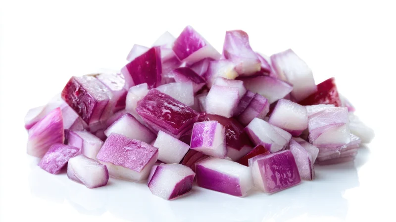 Diced red onions piled on a white surface