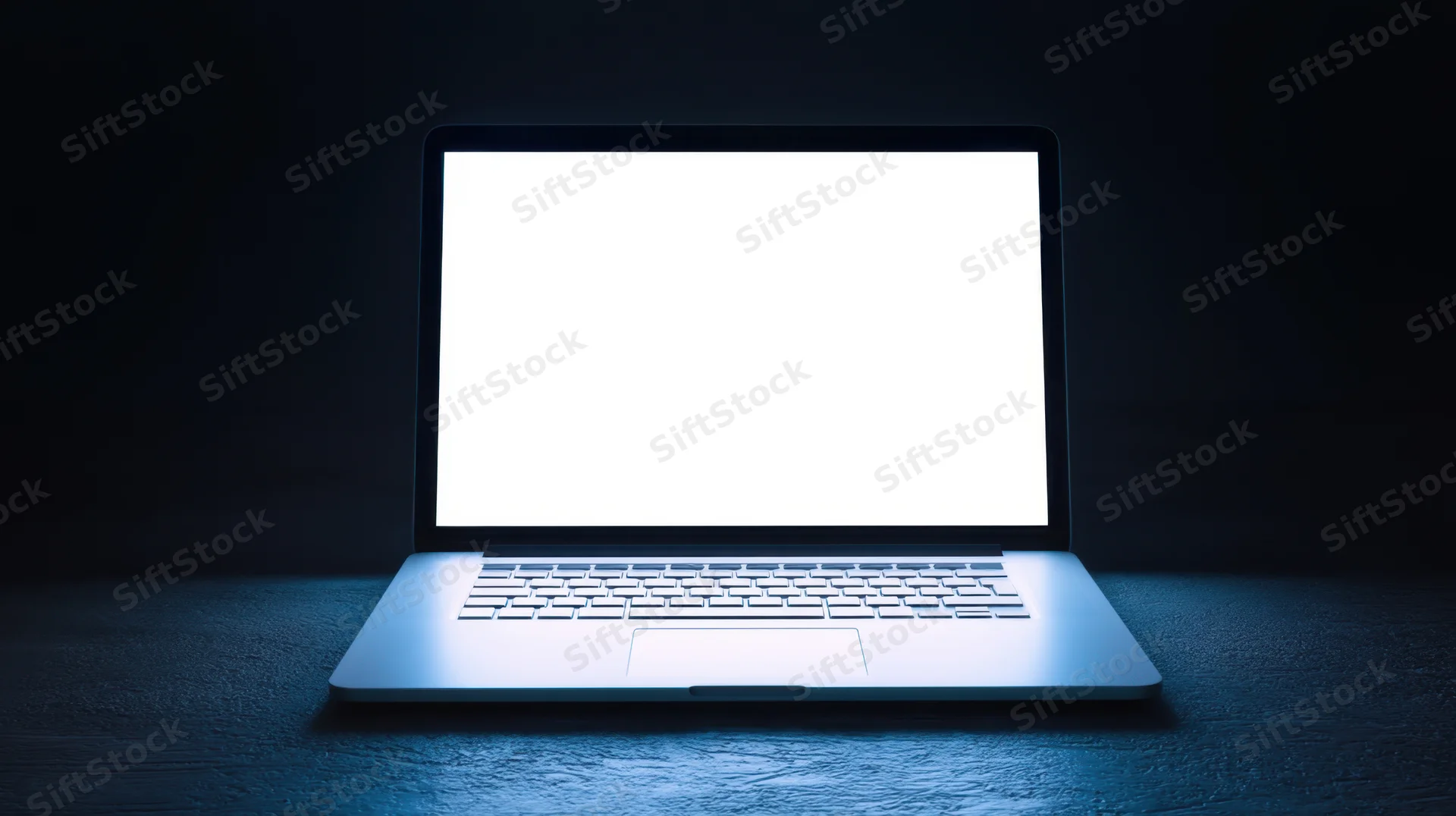 Sleek laptop with bright white screen on dark surface