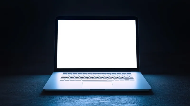 Sleek laptop with bright white screen on dark surface