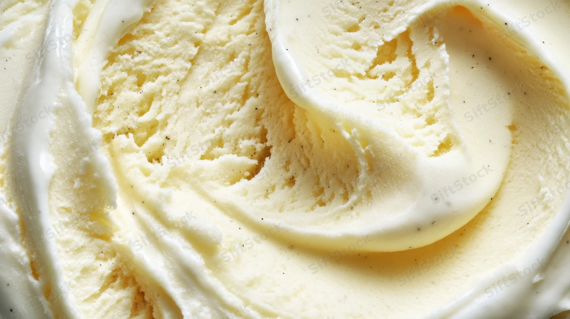 Closeup of creamy vanilla ice cream with swirls and speckled texture