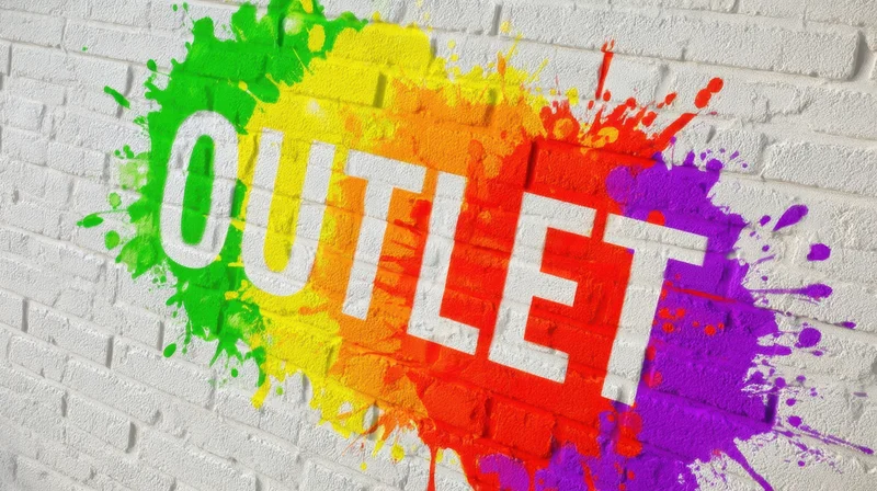 Rainbow paint splashes form the word outlet on a white brick wall