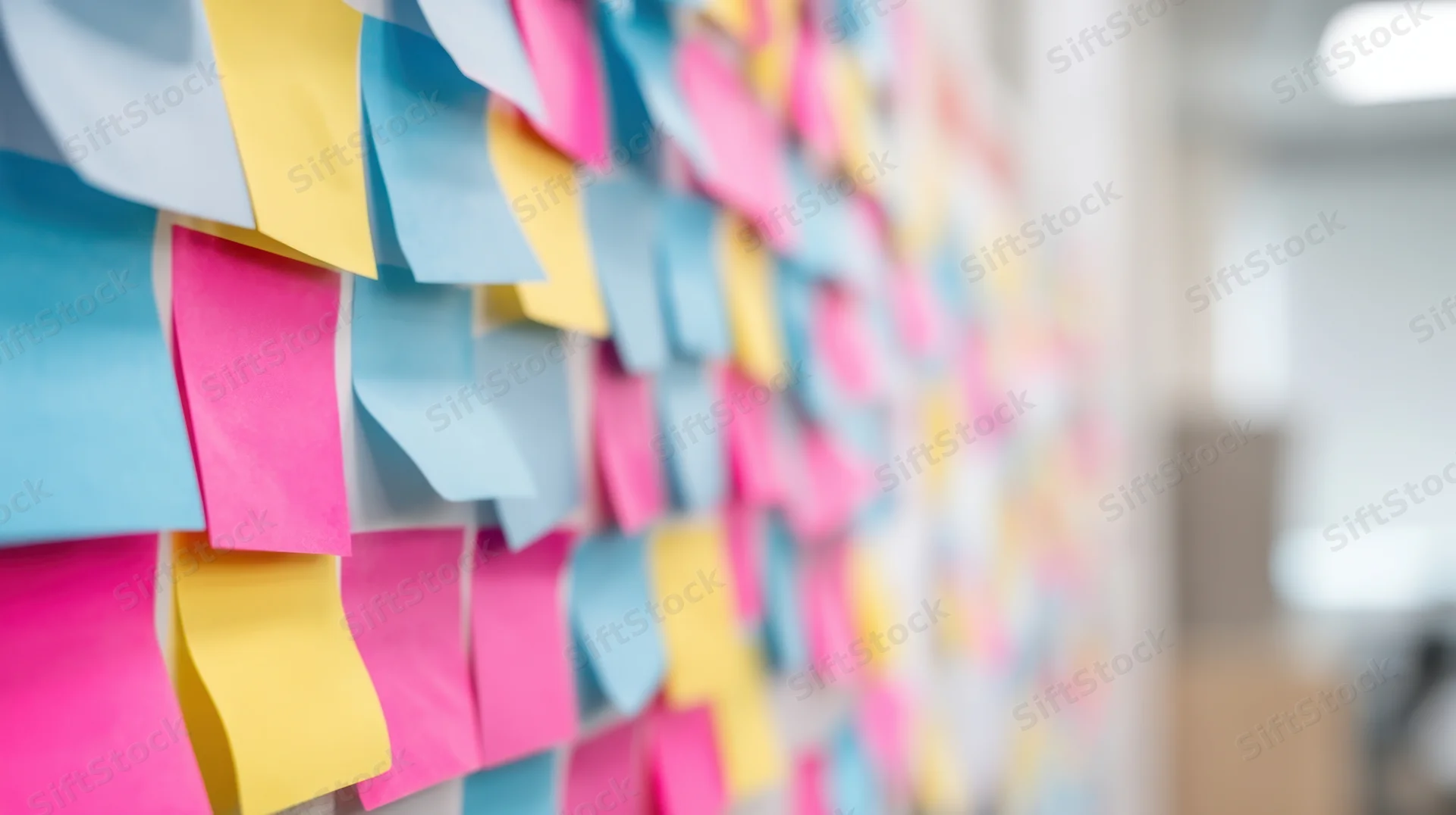 Colorful sticky notes arranged on a wall in an office setting