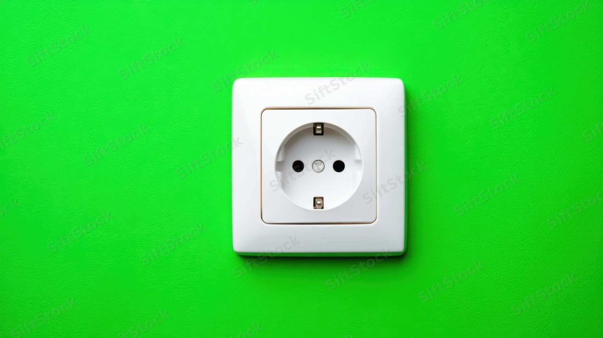 White electrical socket mounted on a green wall