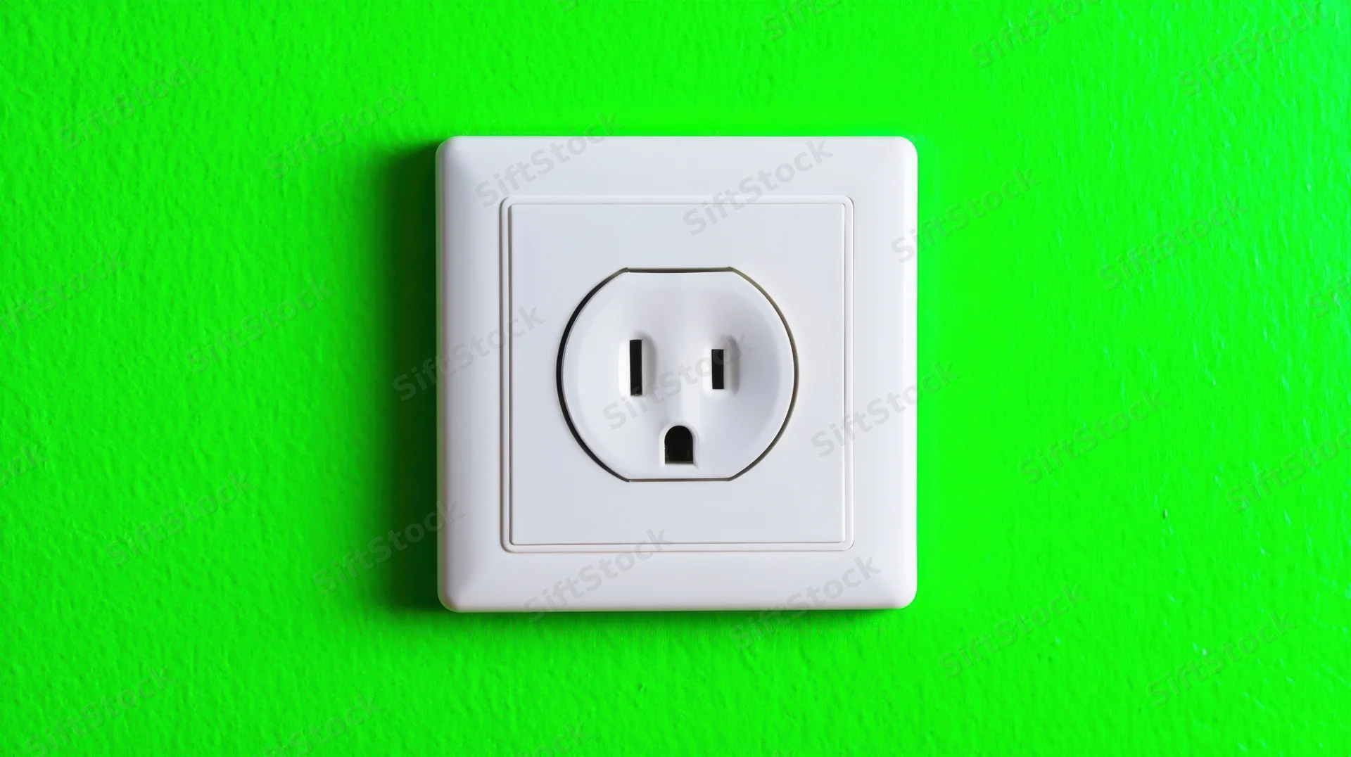 White electrical outlet mounted on a bright green wall