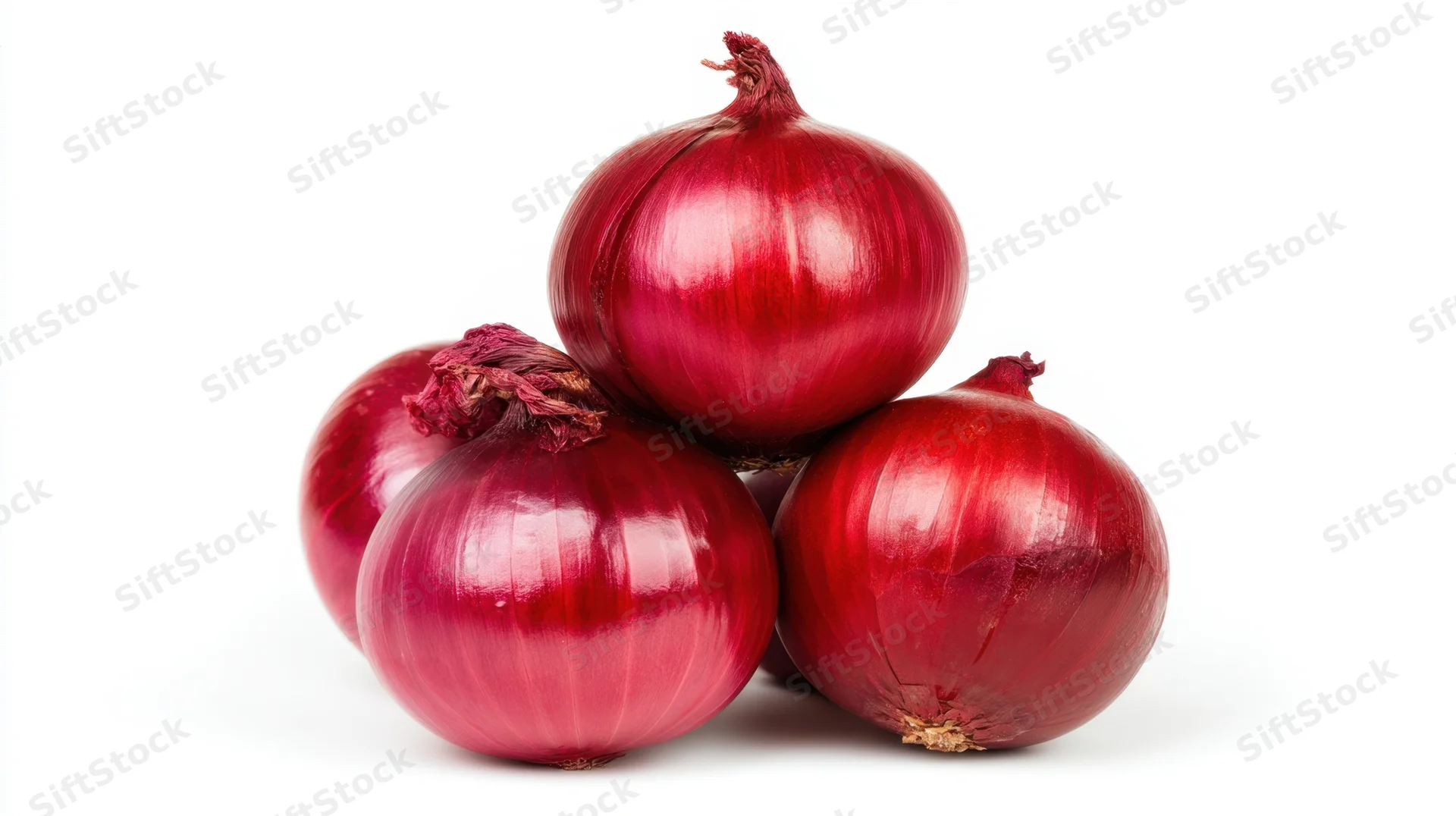 Four red onions stacked in a pile on a white background