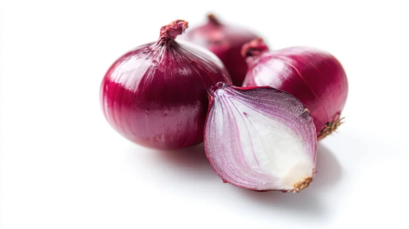Fresh red onions with one halved on white background