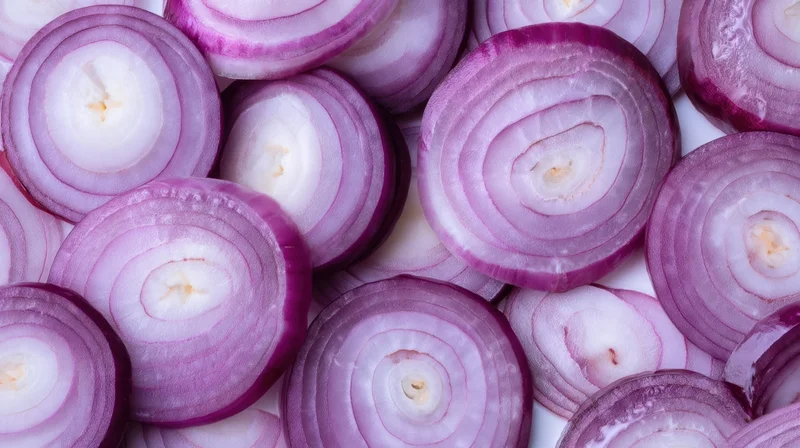 Sliced red onions arranged in a close-up top view on a white surface