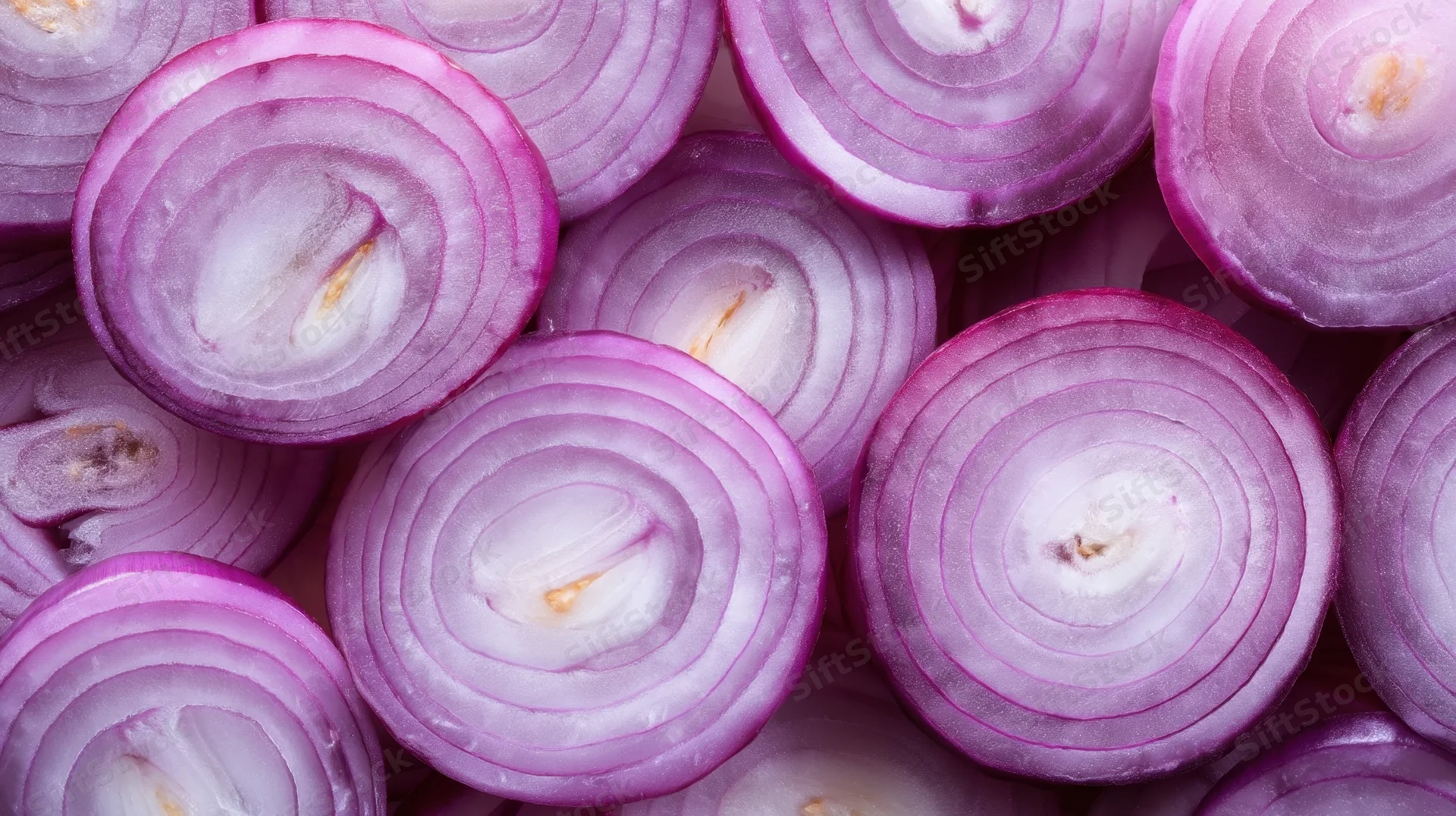 Closeup of freshly sliced red onions arranged in overlapping circular layers showing purple and white concentric rings