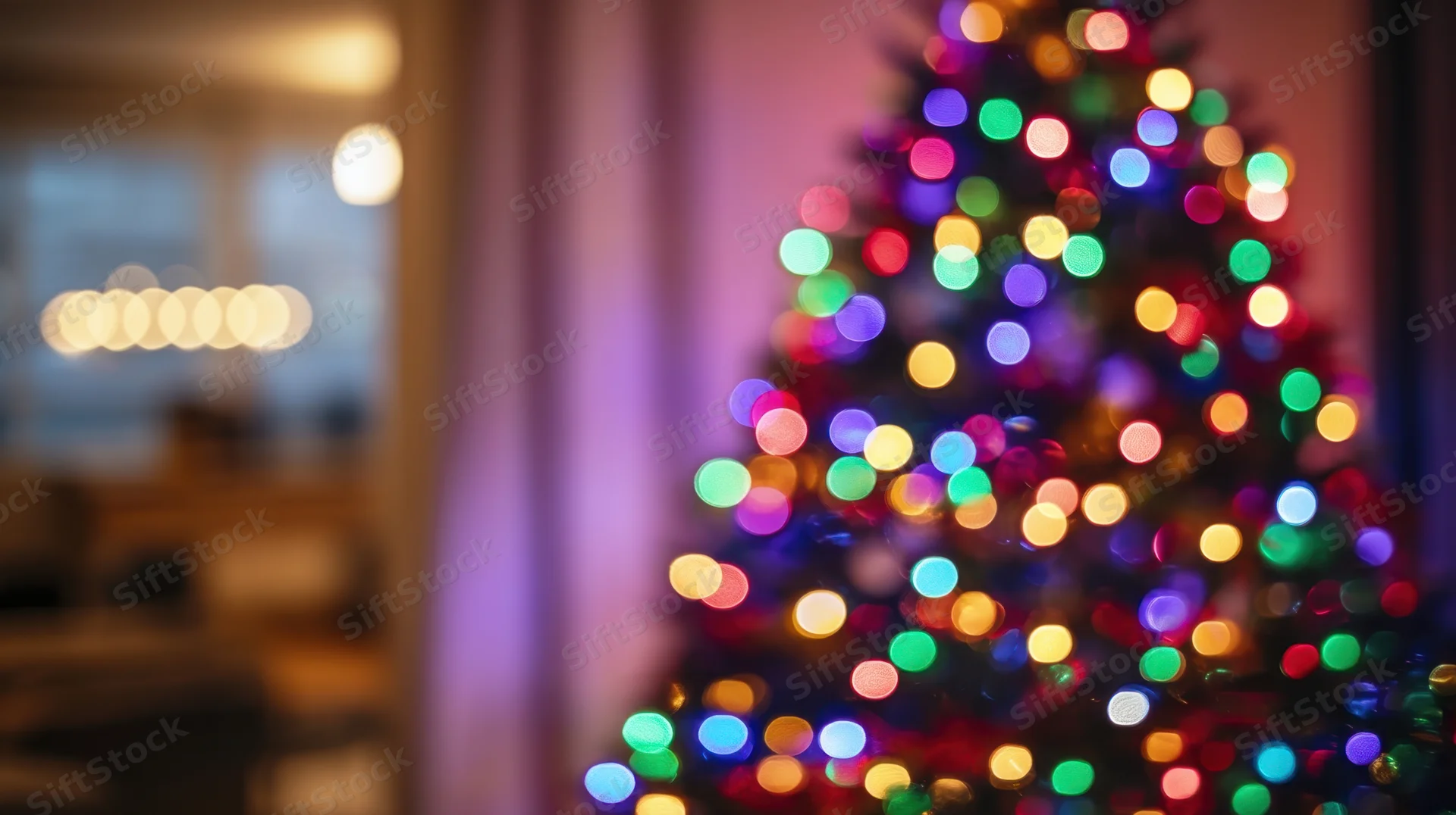 Blurred christmas tree with colorful lights glowing in a warm indoor setting