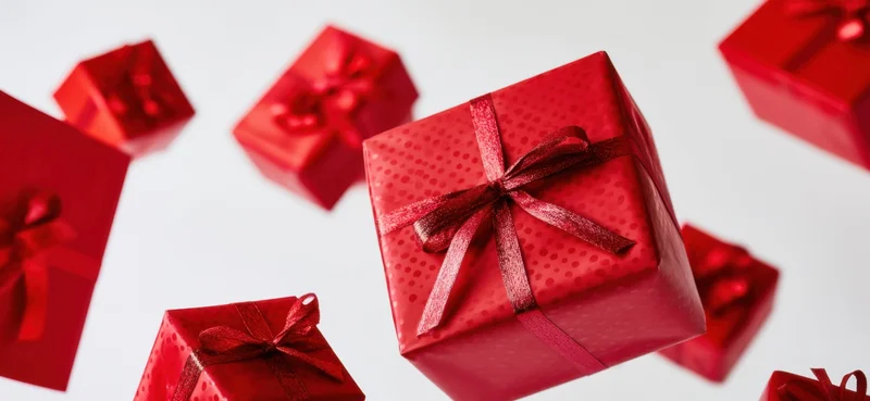 Red gift boxes with shiny ribbons arranged on white background