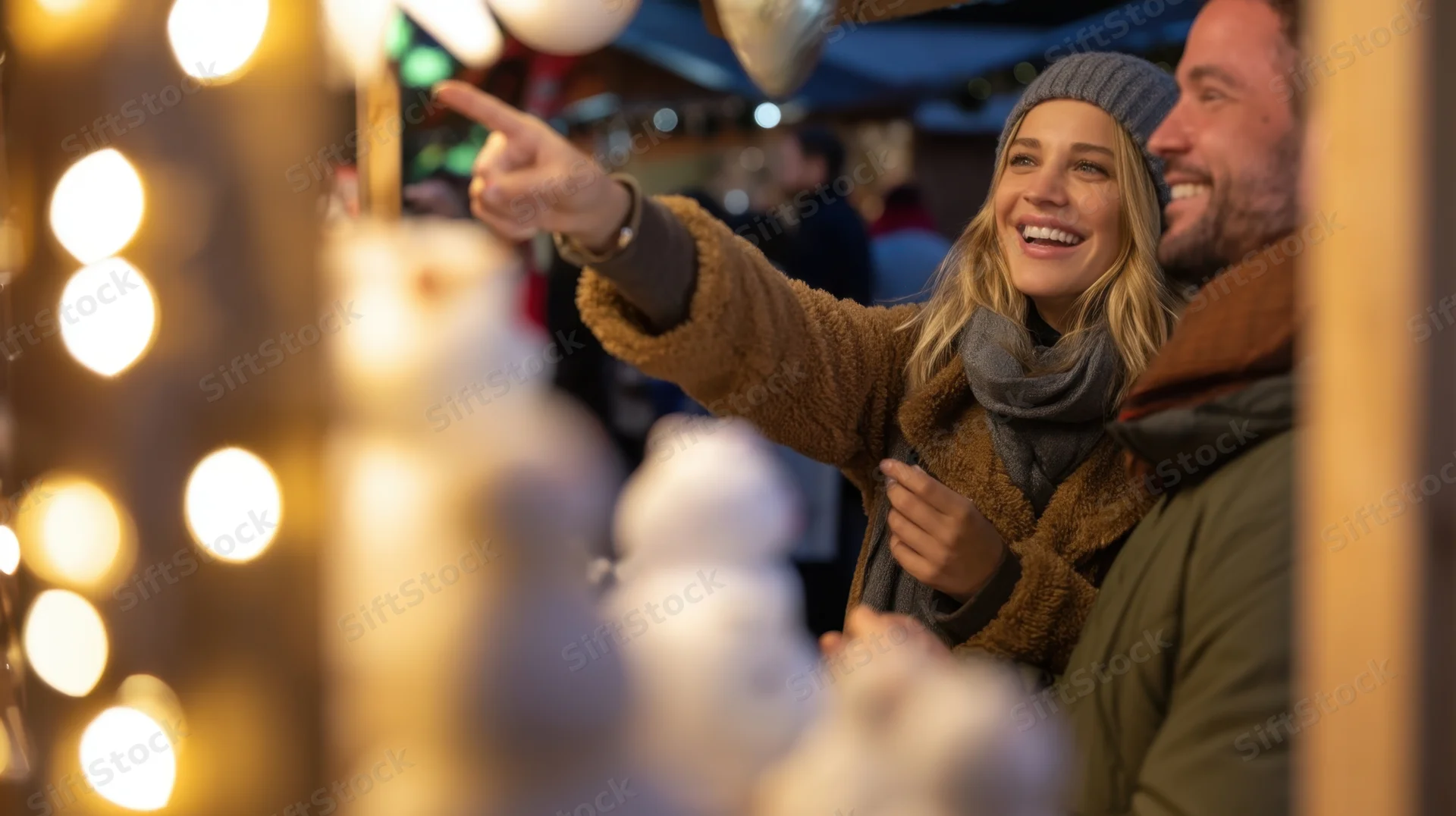 Woman pointing at decorations with man at festive outdoor market