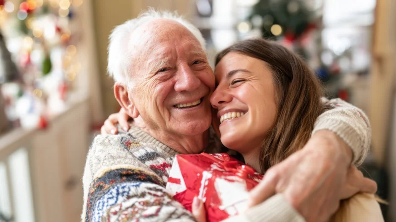 Grandfather and granddaughter hugging with a wrapped gift in a decorated home