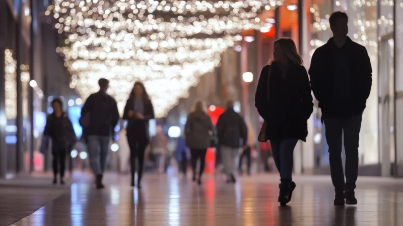 Couple walking along a brightly lit shopping street at night with festive lights overhead