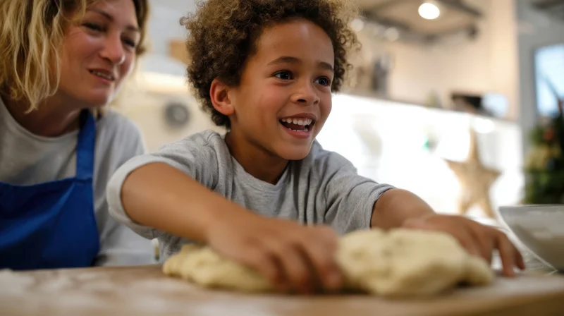 Child kneading dough with smiling woman in kitchen during holiday baking