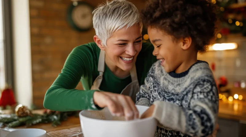 Woman and child smiling while baking together in a cozy kitchen decorated for christmas