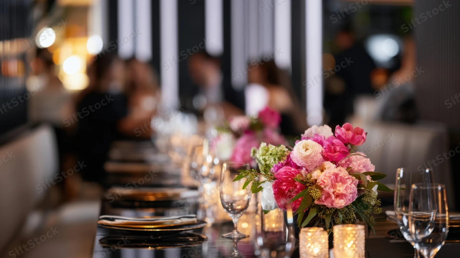 Long dining table set with floral centerpiece and candles in a modern restaurant interior