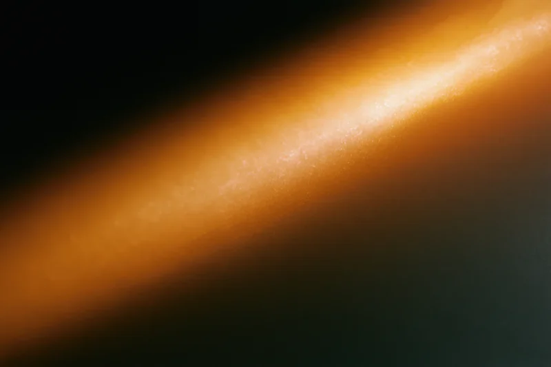 The Diagonal Orange Light Beam Across a Dark Abstract Backdrop