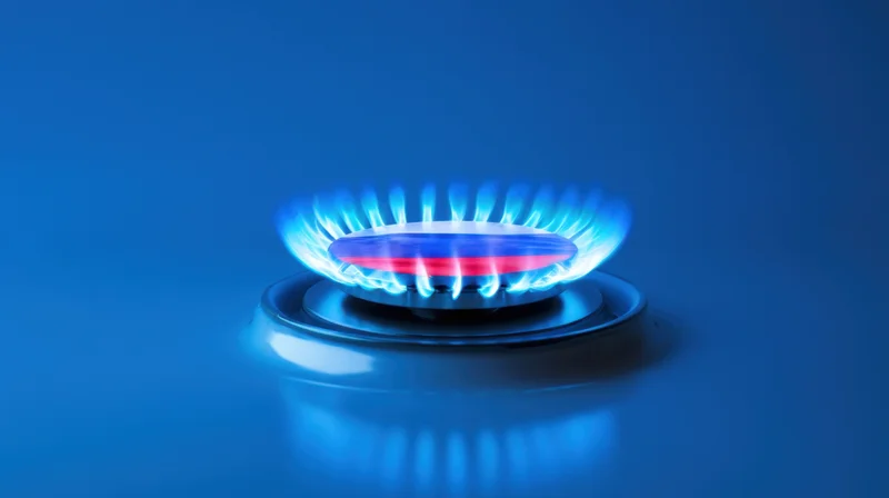 Gas burner with blue flame ignited on a kitchen stove surface