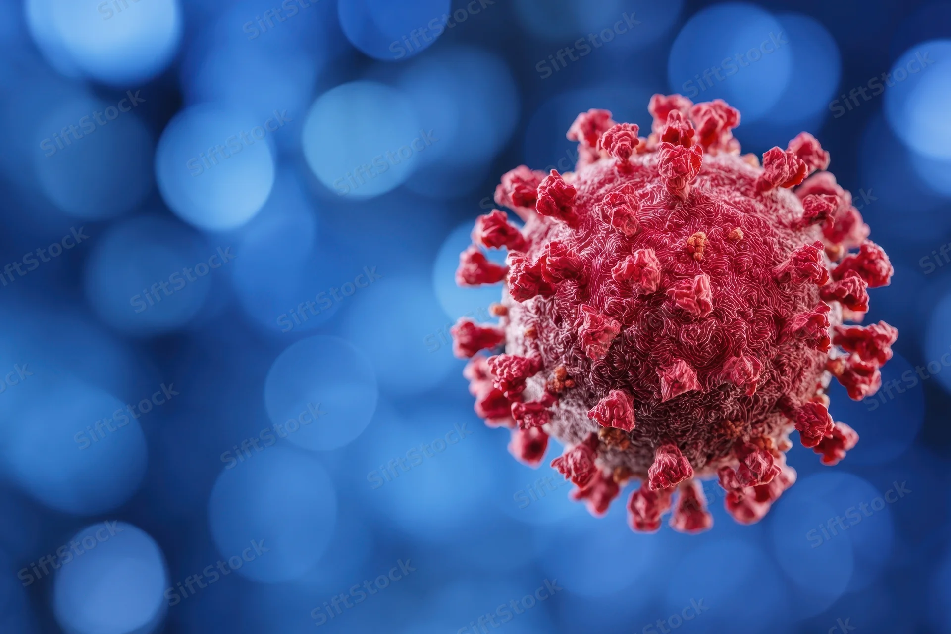 Red coronavirus particle with spike proteins on blue bokeh background