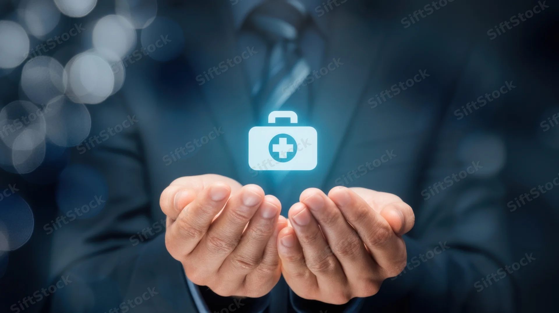 Man in suit holding glowing medical symbol in hands