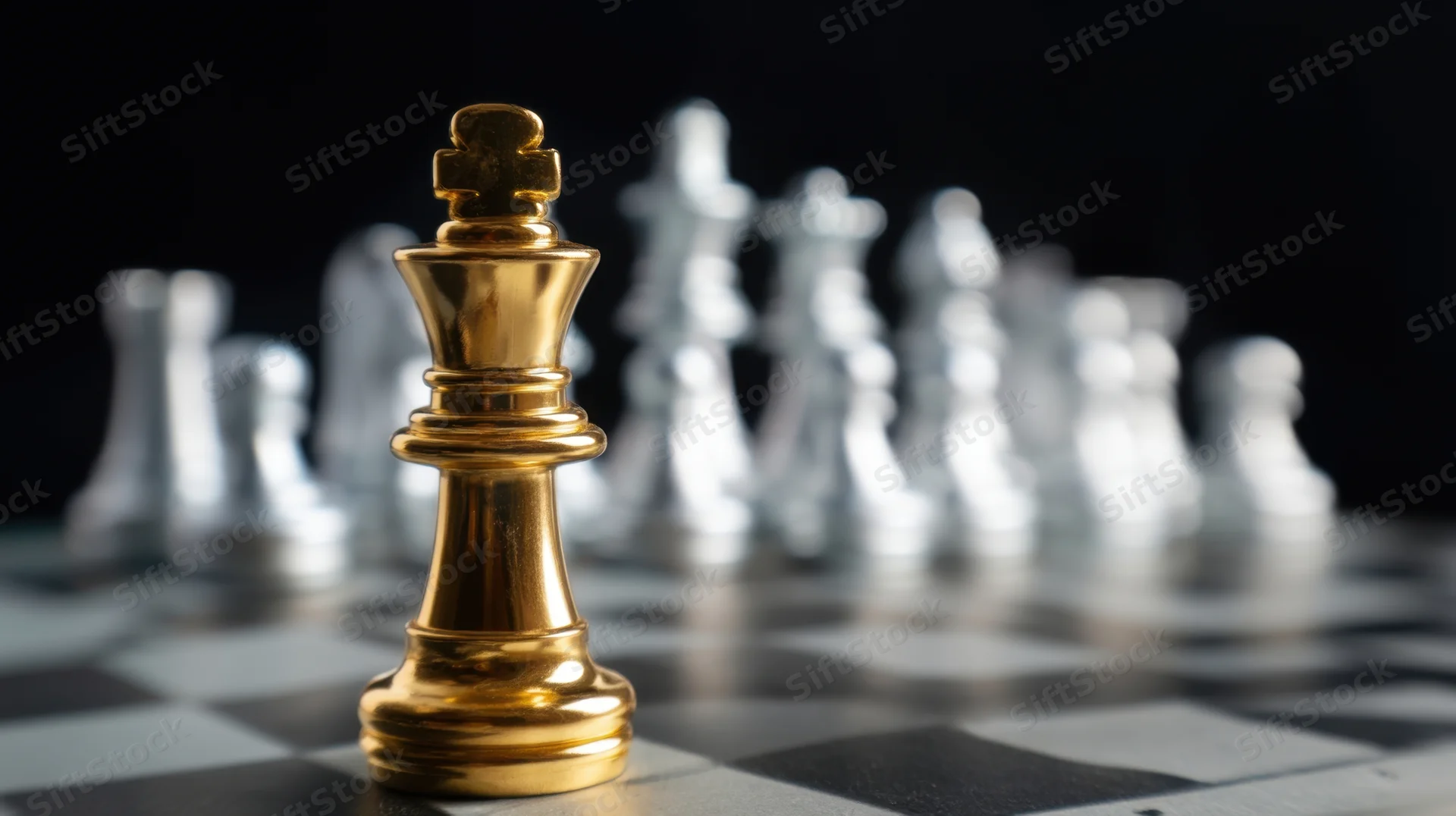 Golden chess king in focus on a checkered board with silver pieces blurred behind it