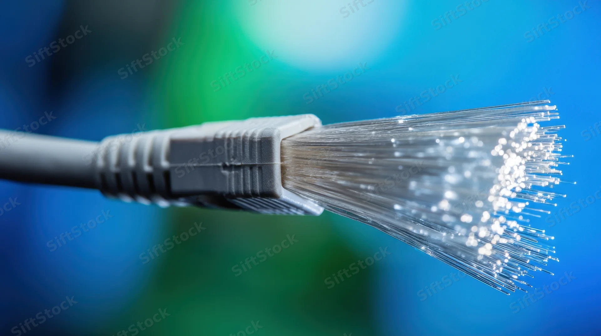 Close-up of fiber optic cable end with glowing glass strands against blue and green background