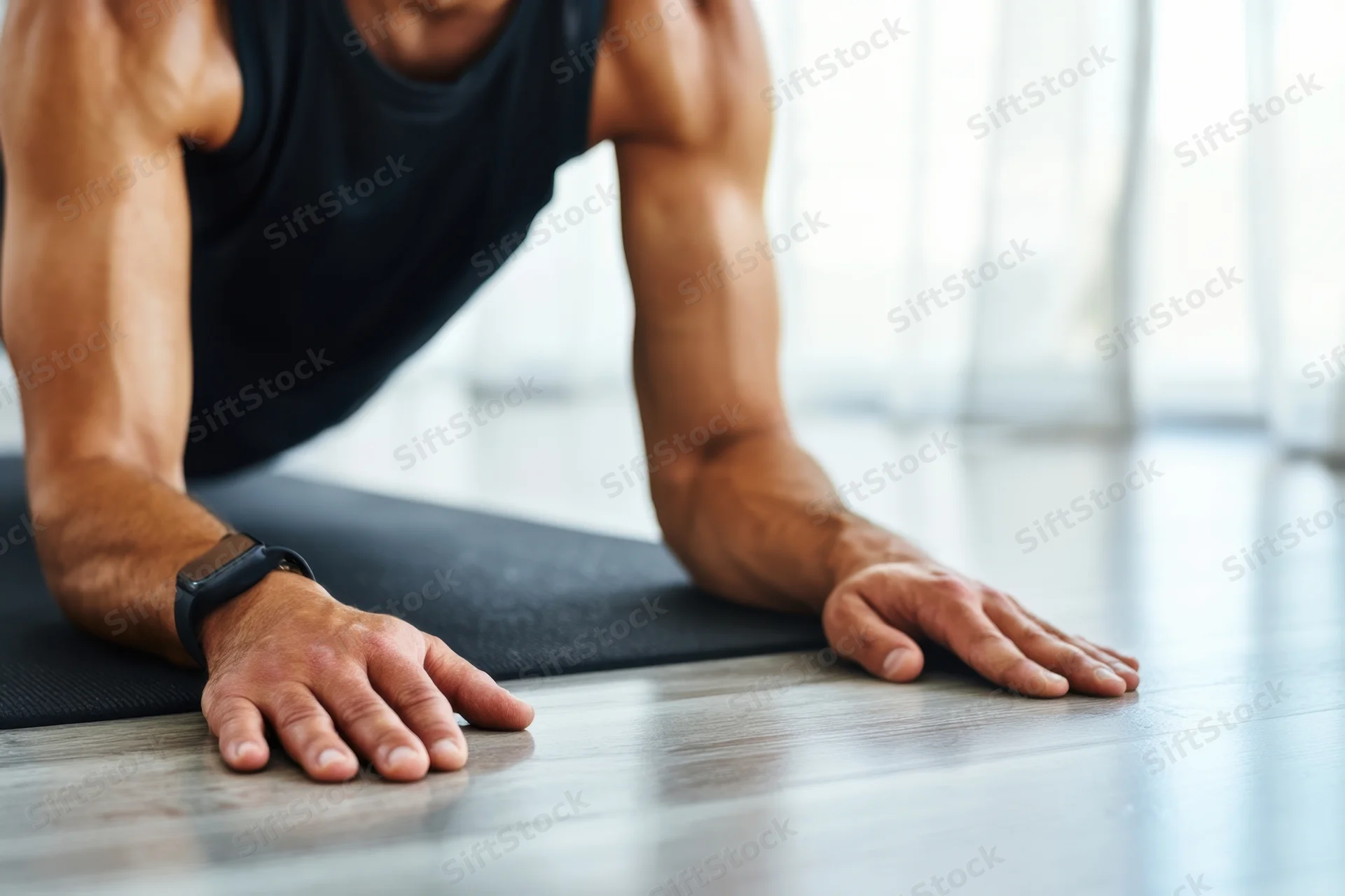 Man doing pushup on exercise mat indoors with smartwatch on wrist
