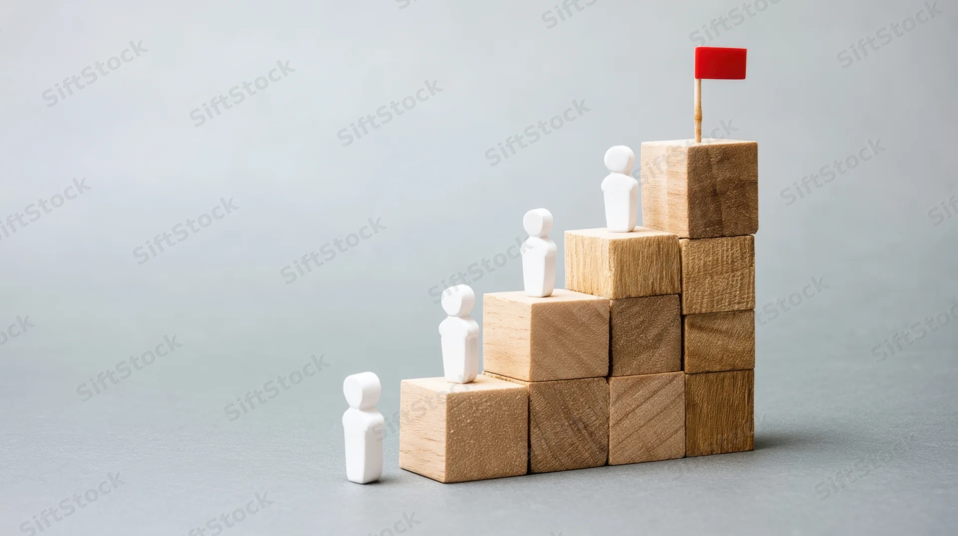 White figures ascending wooden blocks toward a red flag at the top