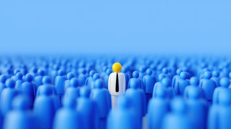 White figurine with yellow head standing among blue crowd in digital render