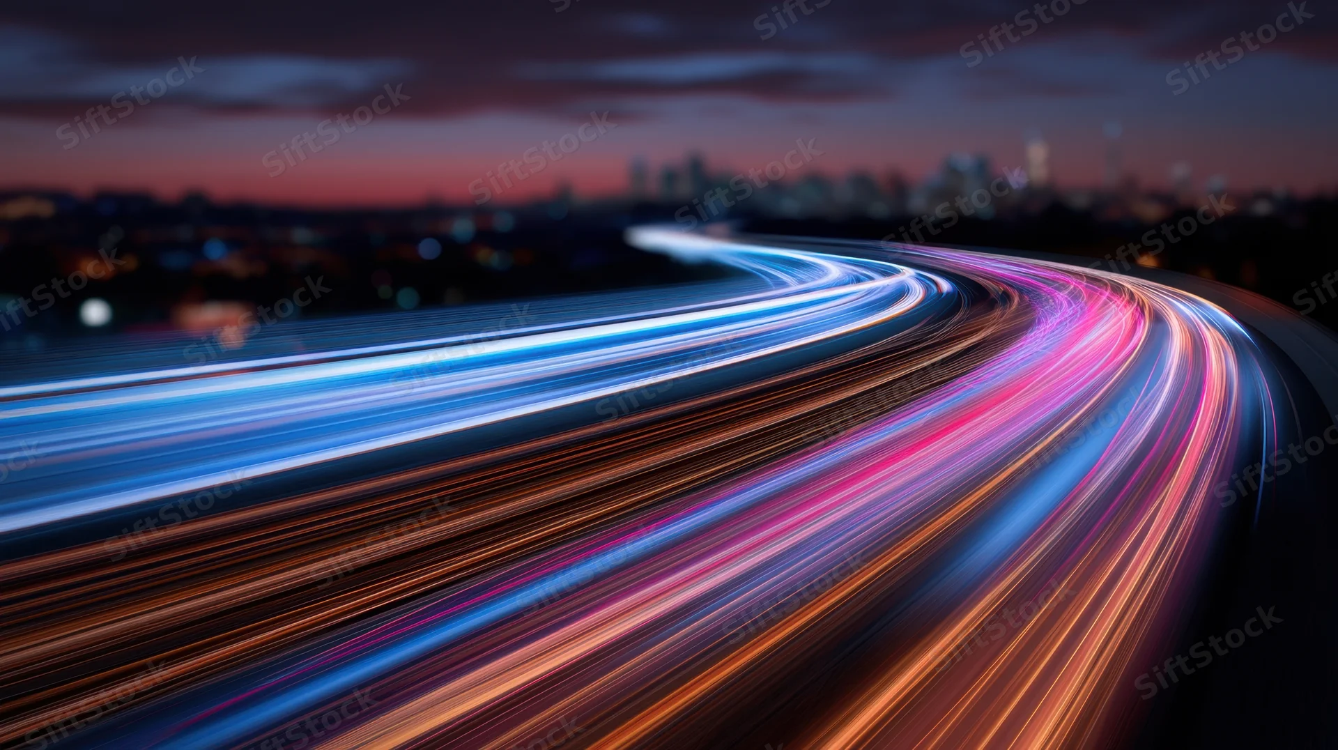 Colorful light trails from moving vehicles on a highway at night with city skyline in the distance