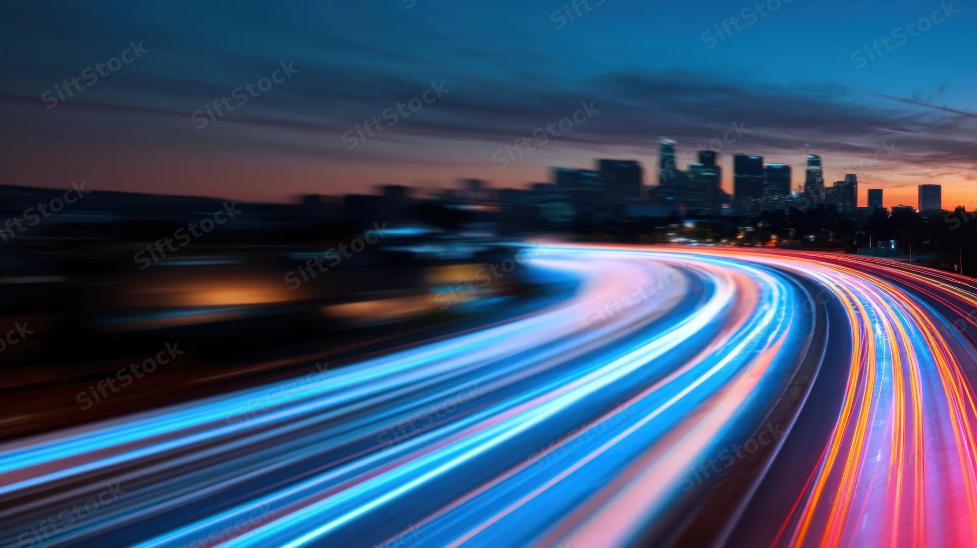 Blurred light trails from moving vehicles on a highway at twilight with city skyline in the distance