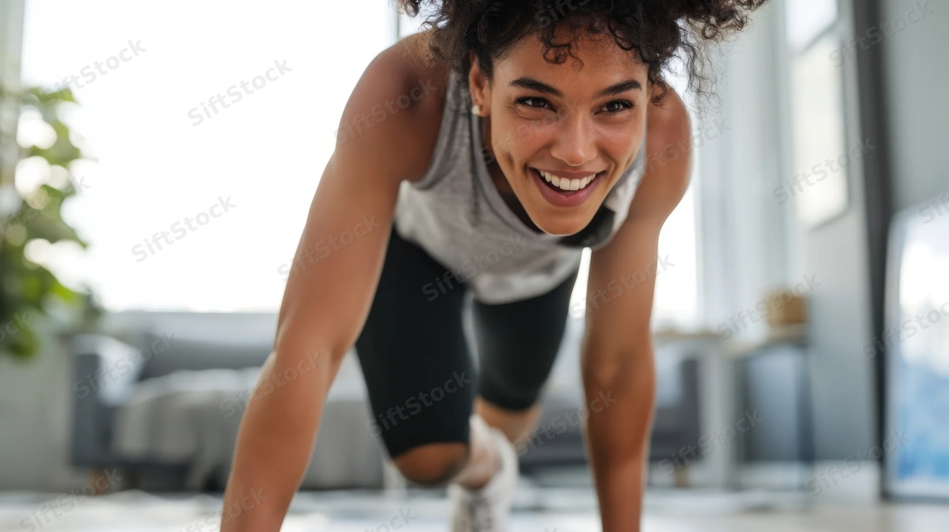 Woman smiling while doing pushups in a living room
