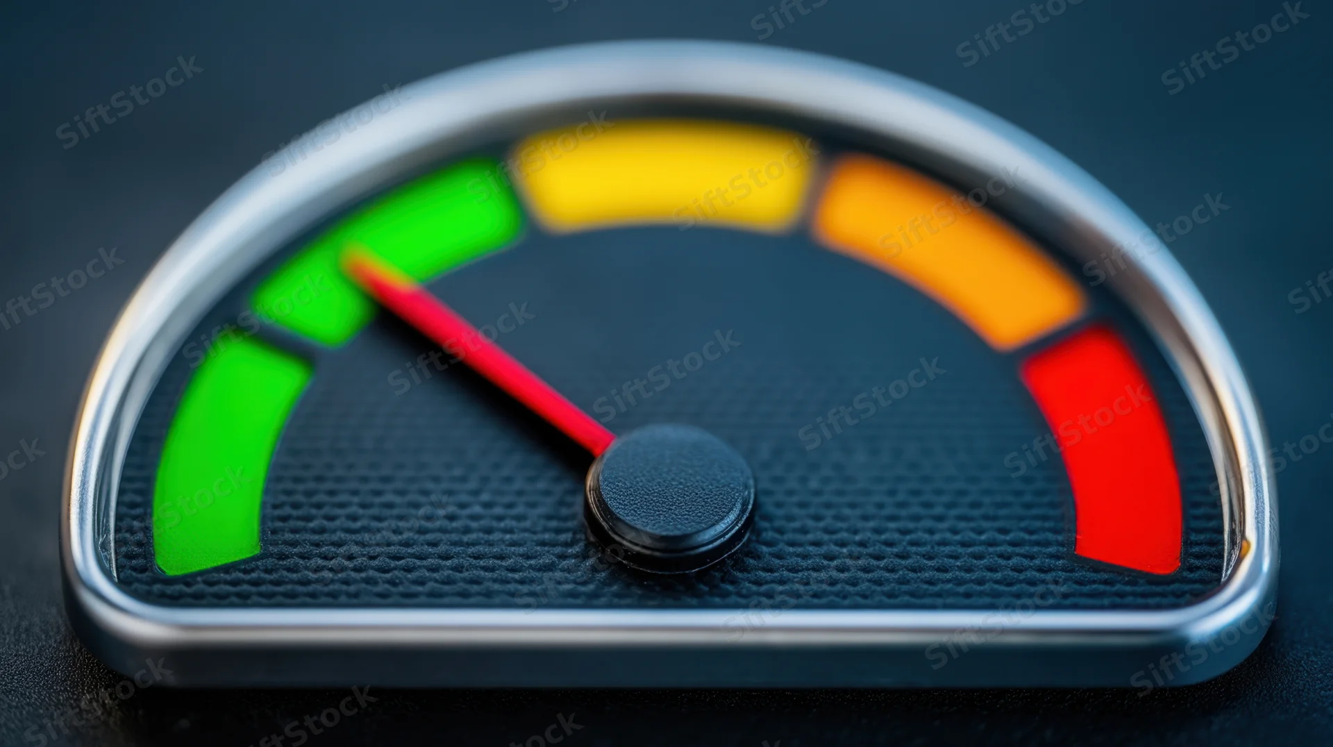 Close-up of a gauge with red needle pointing to green section on a textured black face with metallic frame