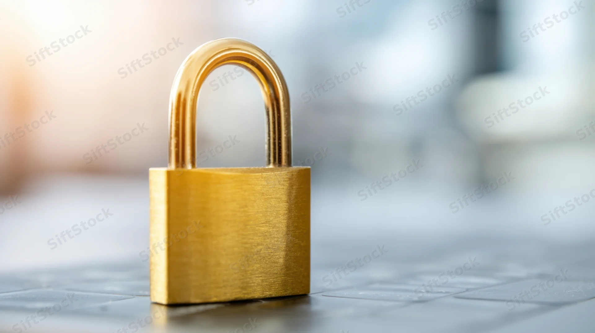 Golden padlock standing on a tiled floor with blurred office background