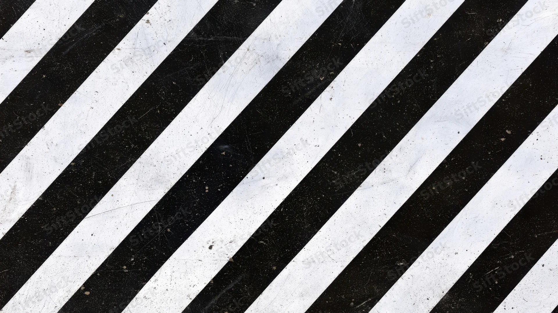 Diagonal black and white stripes on a worn textured surface
